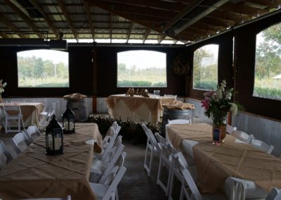 Immerse yourself in the serenity of a noon-day banquet held inside our event barn at Equus Run Vineyards. The gentle streams of light enhance the beauty of the empty table settings, awaiting the arrival of guests, while the venue's rusti