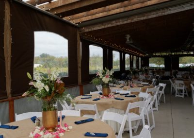 Experience the pinnacle of elegance as the sun's rays cast a soft, golden glow upon the wedding reception in our event barn at Equus Run Vineyards. The intimate setting, adorned with exquisite table settings, blossoming floral arrangements, and the joyful clinking of glasses, sets the stage for a memorable banquet.